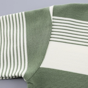 Detail of green and white striped knit fabric showing texture and shoulder stitching