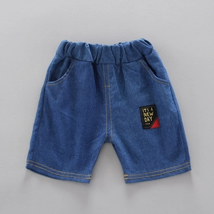 Detail of dark blue denim shorts for kids featuring elastic waist and embroidered patch