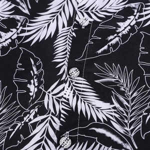 Macro shot of tropical palm leaf print on lightweight fabric and engraved fashion buttons