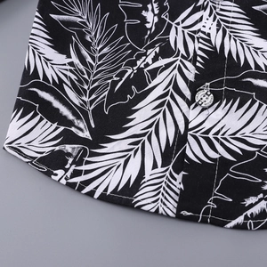 Detail of tropical leaf print shirt showing fine stitching and FASHION engraved button