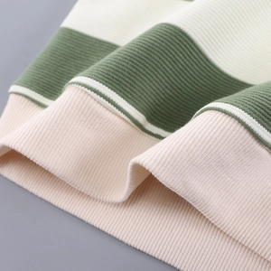 Macro shot of striped knit fabric with ribbed cuffs in green white and pink colors