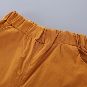 Detail of baby striped outfit elastic waistband and side pockets in caramel cotton