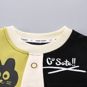 Detail of kids round neck t-shirt with color block design, button and cartoon cat print