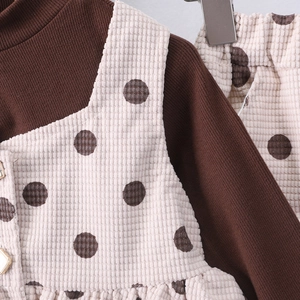 Dettaglio del gilet in velluto a pois e della maglia a coste per bambine in autunno