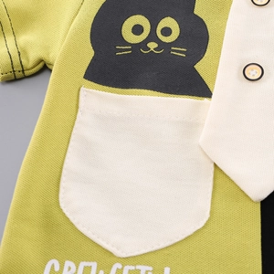 Close-up of green cotton polo shirt featuring a black cat print and white pocket detail