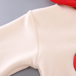 Λεπτομέρεια από κρέμα fleece με κόκκινη ραφή στον ώμο του κοριτσίστικου φούτερ