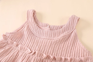 Detail view of pink sleeveless top featuring pleated fabric and ruffled collar texture