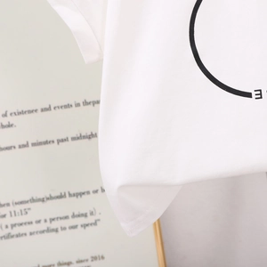 Gros plan sur la texture du t-shirt en coton blanc et l'imprimé minimaliste pour filles