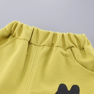 Detailed macro view of yellow children's cotton shorts with elastic waistband and pockets