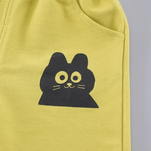 Detail of yellow piqué fabric with cute black cat cartoon print for boys' outfit