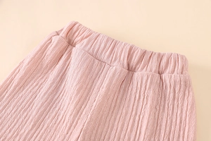 Detail of pink kids' trousers with elastic waistband and seersucker textured fabric