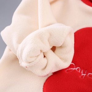 Λεπτομερής λήψη από μπεζ ύφασμα fleece με κέντημα κόκκινης καρδιάς και λεπτή ραφή
