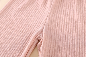 Close-up of pink pleated fabric texture on kids' summer casual straight-leg pants