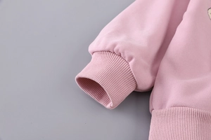 Detail of pink sweatshirt showing ribbed cuffs and soft knitted fabric texture