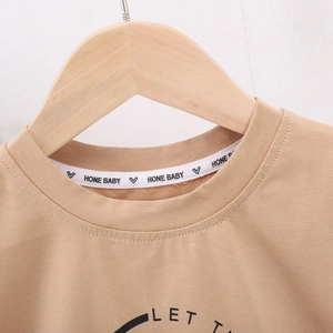 Détail de l'encolure du t-shirt kaki en coton avec bande de maintien et logo imprimé