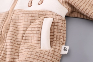 Detail shot of plaid fleece jacket showing size 80 tag and contrast pocket stitching