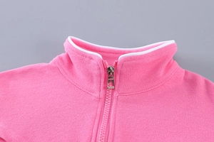 Détail du col d'un sweat de sport rose pour fille avec passepoil blanc et fermeture éclair