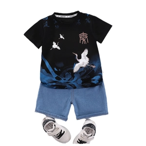 Boys summer set with crane print T-shirt, denim shorts and white sneakers on white backdrop