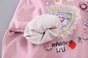 Detail of pink fleece-lined sweatshirt fabric with lace heart bear patch and print