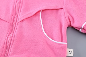 Détail de la veste zippée rose pour fille montrant l'étiquette 80 et le tricot doux