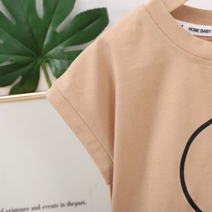 Détail du t-shirt pour bébé en coton tricoté kaki montrant le col rond et la texture