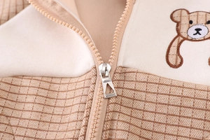 Detailed close-up of child jacket with zipper and cute embroidered teddy bear pattern