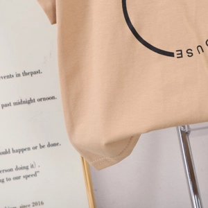 Détail du t-shirt en coton abricot avec coutures doubles et imprimé graphique circulaire