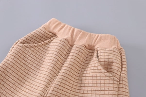 Detail of children's plaid pants featuring elastic waistband and functional side pockets