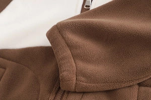 Détail de la texture polaire chaude avec fermeture éclair et contraste blanc-marron enfant