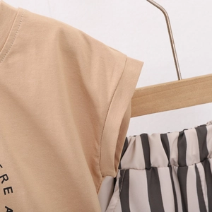 Détail de couture sur t-shirt kaki pour enfants avec imprimé REA et short rayé assorti