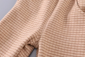 Close-up of brown plaid toddler pants showing thick woven fabric and fine stitching detail