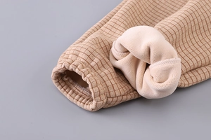 Detailed macro view of beige grid fabric with thick ivory fleece lining and elastic cuffs