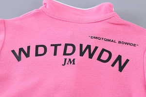 Détail du dos de la veste en tricot rose avec impression de lettres WDTDWDN en noir