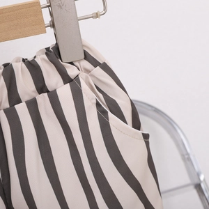 Détail du pantalon rayé pour filles montrant la taille élastique et la couture de poche