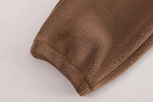 Gros plan sur la texture épaisse en polaire marron de l'ensemble d'hiver pour enfants