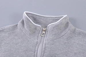 Détail de sweat en maille grise pour fille avec fermeture éclair métallique élégante