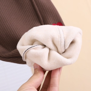Vue détaillée du tissu côtelé marron et doublure polaire sherpa épaisse avec patch coeur rouge