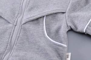 Détail de la veste en tricot gris pour enfant avec fermeture éclair et étiquette taille 80