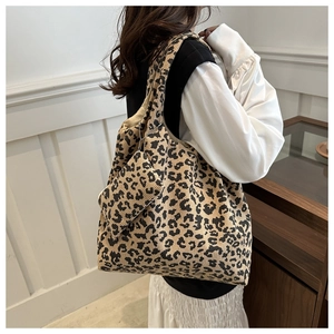 Détail du cabas en velours côtelé léopard avec pochette assortie portée à l'épaule