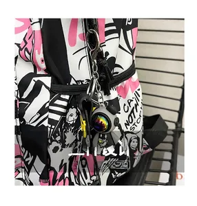 Detail of trendy graffiti backpack with stylish doll charm and bold graphic print