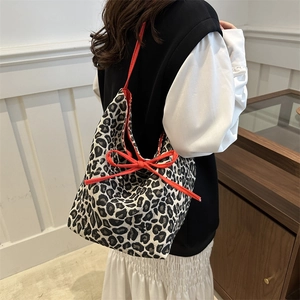 Winter leopard print tote bag with red bow accent and thick jacquard fabric texture