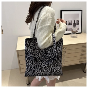 Détail du grand sac cabas à motif léopard en toile grise porté par un mannequin