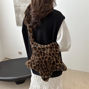 Sac fourre-tout étoile en fausse fourrure léopard porté par un mannequin en intérieur