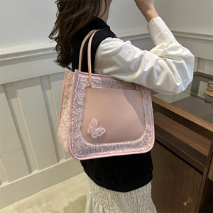Sac cabas rose avec bordure en fourrure et patch papillon porté par un mannequin
