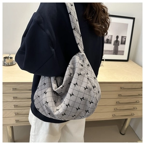 Dettaglio della borsa tote in velluto a coste grigio con fiocchi neri e trapuntatura