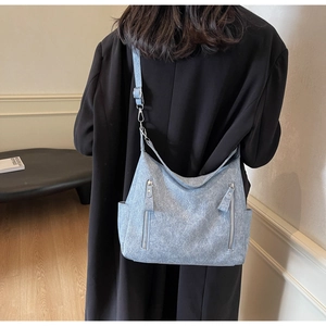 Detail of light blue vintage crossbody bag with symmetrical front zipper pockets