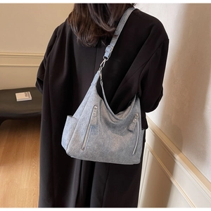Detail of gray vintage textured leather tote bag with vertical decorative zippers