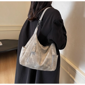 Detail of light gray retro tote bag featuring matte texture and vertical zippers