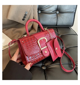 Deep red crocodile texture handbag with gold buckle and matching coin purse on sofa