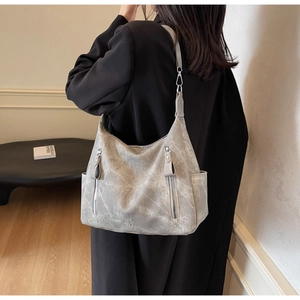 Detail shot of a grey washed leather tote bag showing two vertical zipper pockets